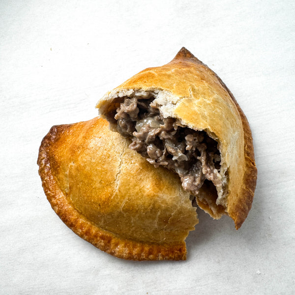 Inside of gluten-free cheesesteak hand pie on white
