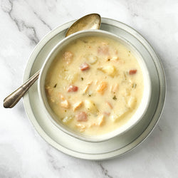 Bowl of soup with a spoon on a marble surface